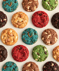 A top-down flat lay of colorful chocolate chip cookies arranged in a neat circular pattern on a light off-white background.