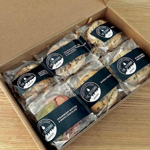 Box of assorted cookies with clear packaging and visible branding on a wooden surface
